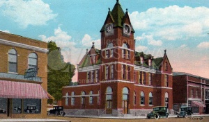 Colourized image of a three storey, red brick building with prominent central tower