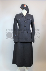 A grey/blue uniform consisting of a knee length skirt, jacket, and bonnet style hat. The hat and jacket feature a Red Cross patch