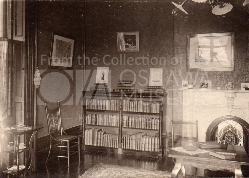 Sepia photo of a room with a bookcase and fireplace